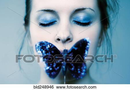 Stock Photograph - Caucasian teenage girl covering mouth with blue butterfly. Fotosearch
