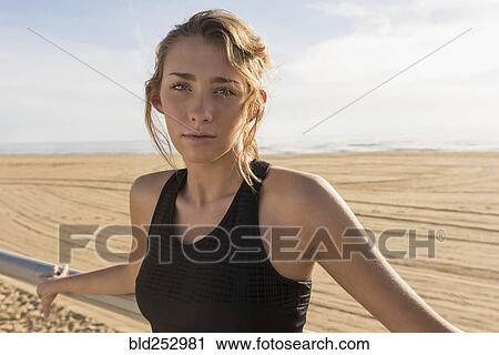 Stock Image - Caucasian teenage girl leaning on railing at beach. Fotosearch
