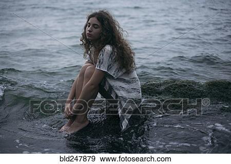 Caucasian teenage girl sitting on rock in ocean View Large Photo Image Stock Photo - Caucasian teenage girl sitting on rock in ocean. Fotosearch