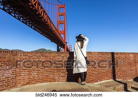 Stock Photography - "Caucasian woman admiring Golden Gate Bridge, San Francisco, California, United States". Fotosearch