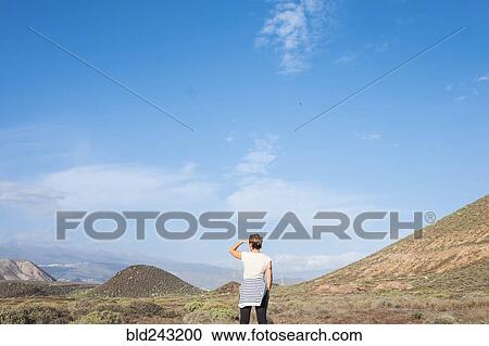 Stock Image - Caucasian woman admiring scenic view of distant landscape. Fotosearch