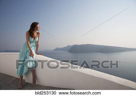 Stock Image - Caucasian woman admiring scenic view of ocean. Fotosearch