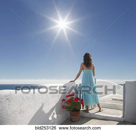 Stock Photograph - Caucasian woman admiring scenic view of ocean. Fotosearch