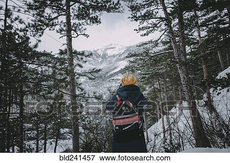 Stock Photo - Caucasian woman admiring snowy forest. Fotosearch