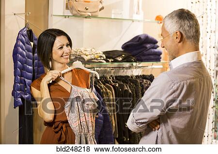 Caucasian woman asking man for advice about dress View Large Photo Image Stock Photo - Caucasian woman asking man for advice about dress. Fotosearch