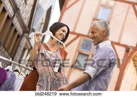 Stock Photo - Caucasian woman asking man for advice about dress. Fotosearch