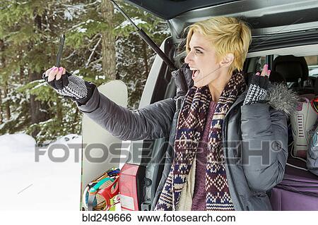 Caucasian woman at car posing for cell phone selfie in winter View Large Photo Image Stock Photograph - Caucasian woman at car posing for cell phone selfie in winter. Fotosearch