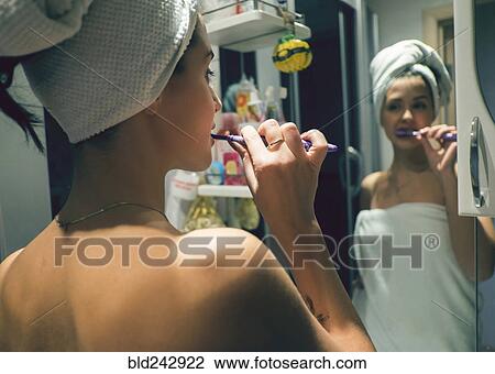 Caucasian woman brushing teeth in mirror View Large Photo Image Stock Image - Caucasian woman brushing teeth in mirror. Fotosearch