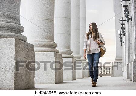 Stock Photography - Caucasian woman carrying backpack at school. Fotosearch