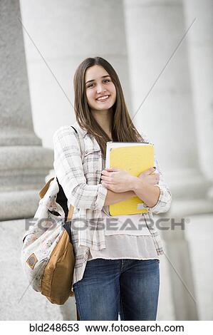 Stock Image - Caucasian woman carrying school notebook. Fotosearch