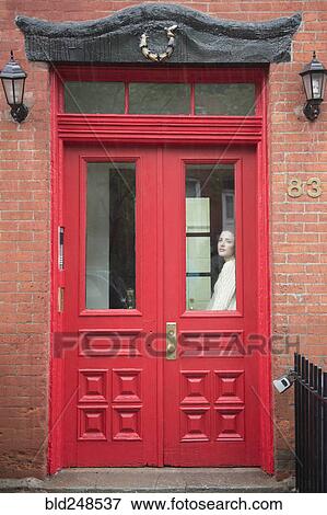 Caucasian woman daydreaming behind red door View Large Photo Image Stock Photo - Caucasian woman daydreaming behind red door. Fotosearch
