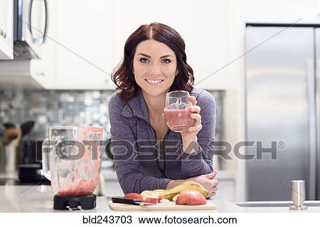 Caucasian woman drinking fruit smoothie in domestic kitchen View Large Photo Image Stock Image - Caucasian woman drinking fruit smoothie in domestic kitchen. Fotosearch