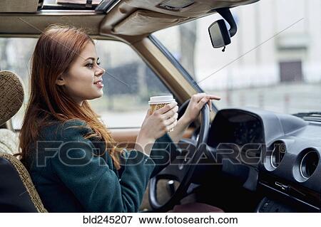 Caucasian woman driving car and drinking coffee View Large Photo Image Stock Photo - Caucasian woman driving car and drinking coffee. Fotosearch
