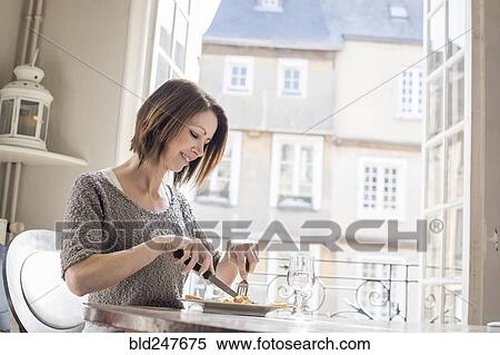 Stock Photography - Caucasian woman eating a meal. Fotosearch