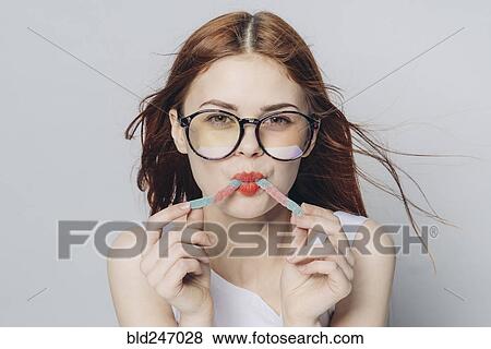 Stock Photo - Caucasian woman eating candy in wind. Fotosearch