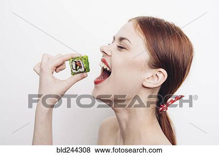 Stock Photo - Caucasian woman eating sushi. Fotosearch