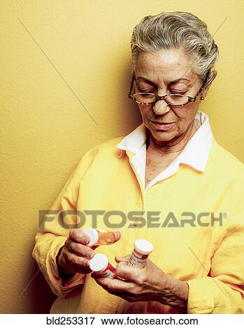 Caucasian woman examining pill bottles View Large Photo Image Stock Photo - Caucasian woman examining pill bottles. Fotosearch