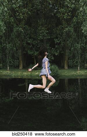 Caucasian woman floating over lake View Large Photo Image Stock Photo - Caucasian woman floating over lake. Fotosearch