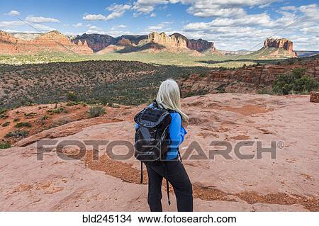 Picture - Caucasian woman hiking in desert landscape. Fotosearch