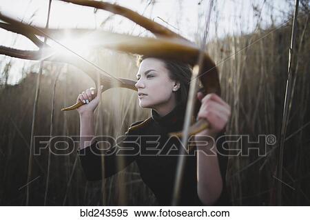Stock Photography - Caucasian woman holding antlers around head. Fotosearch