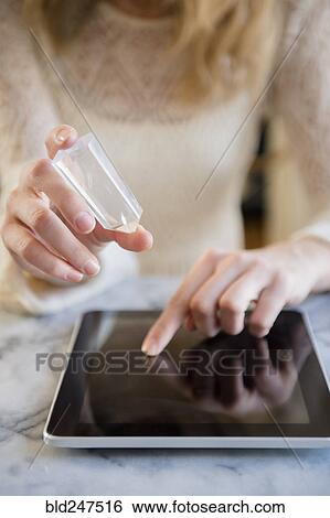 Caucasian woman holding crystal and using digital tablet View Large Photo Image Stock Photograph - Caucasian woman holding crystal and using digital tablet. Fotosearch