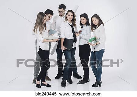 Caucasian woman holding laptop near co-workers reading paperwork View Large Photo Image Stock Photography - Caucasian woman holding laptop near co-workers reading paperwork. Fotosearch