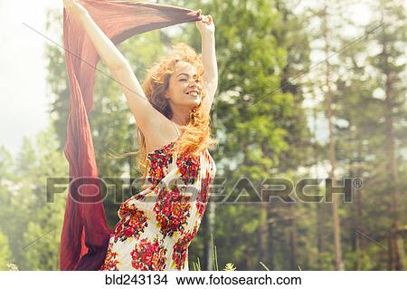 Picture - Caucasian woman holding scarf in wind. Fotosearch