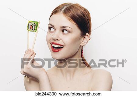 Caucasian woman holding sushi with chopsticks View Large Photo Image Stock Image - Caucasian woman holding sushi with chopsticks. Fotosearch