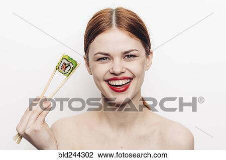 Caucasian woman holding sushi with chopsticks View Large Photo Image Stock Image - Caucasian woman holding sushi with chopsticks. Fotosearch