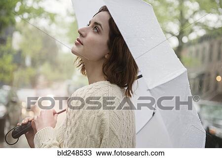 Caucasian woman holding umbrella looking up View Large Photo Image Stock Image - Caucasian woman holding umbrella looking up. Fotosearch