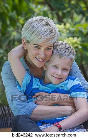 Caucasian woman hugging son outdoors View Large Photo Image Stock Image - Caucasian woman hugging son outdoors. Fotosearch