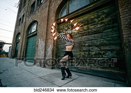 Caucasian woman juggling fire on city sidewalk View Large Photo Image Picture - Caucasian woman juggling fire on city sidewalk. Fotosearch