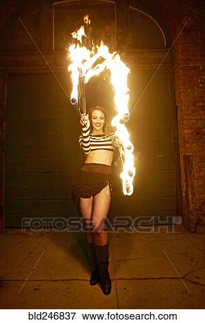 Caucasian woman juggling fire on city sidewalk at night View Large Photo Image Stock Photo - Caucasian woman juggling fire on city sidewalk at night. Fotosearch