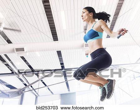 Stock Image - Caucasian woman jumping rope. Fotosearch