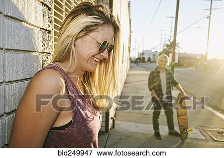 Stock Photo - Caucasian woman laughing on sidewalk. Fotosearch