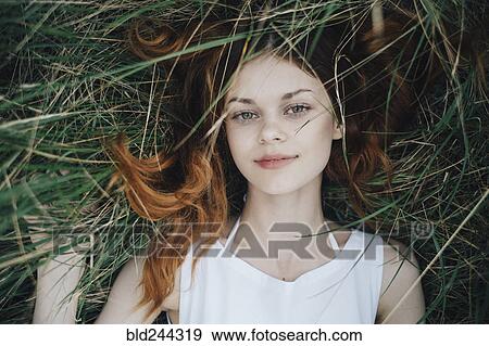 Stock Photo - Caucasian woman laying in grass. Fotosearch