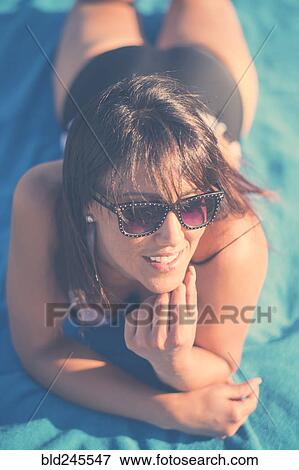 Caucasian woman laying on beach blanket View Large Photo Image Stock Photo - Caucasian woman laying on beach blanket. Fotosearch