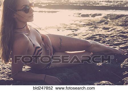 Caucasian woman laying on beach wearing bikini View Large Photo Image Stock Image - Caucasian woman laying on beach wearing bikini. Fotosearch