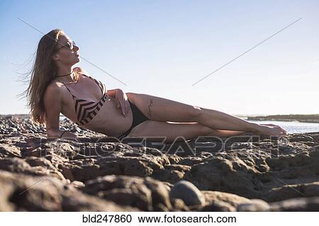 Caucasian woman laying on beach wearing bikini View Large Photo Image Stock Image - Caucasian woman laying on beach wearing bikini. Fotosearch