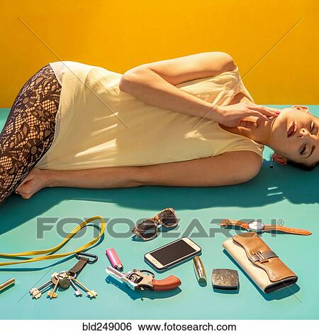 Stock Photograph - "Caucasian woman laying on floor near wallet, gun and cell phone". Fotosearch