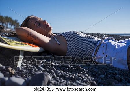Caucasian woman laying on surfboard on beach View Large Photo Image Stock Photography - Caucasian woman laying on surfboard on beach. Fotosearch