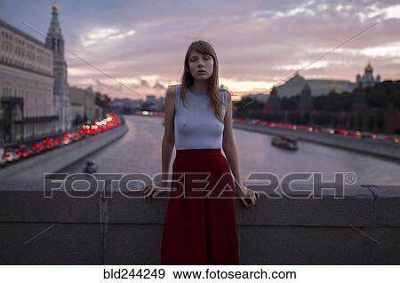 Caucasian woman leaning on bridge over urban canal View Large Photo Image Stock Photo - Caucasian woman leaning on bridge over urban canal. Fotosearch