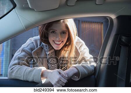 Picture - Caucasian woman leaning on car door. Fotosearch
