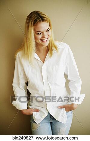 Stock Photo - Caucasian woman leaning on wall looking away. Fotosearch