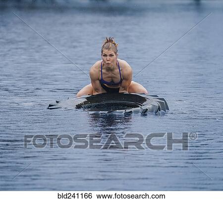 Caucasian woman lifting heavy tire in lake View Large Photo Image Stock Photograph - Caucasian woman lifting heavy tire in lake. Fotosearch