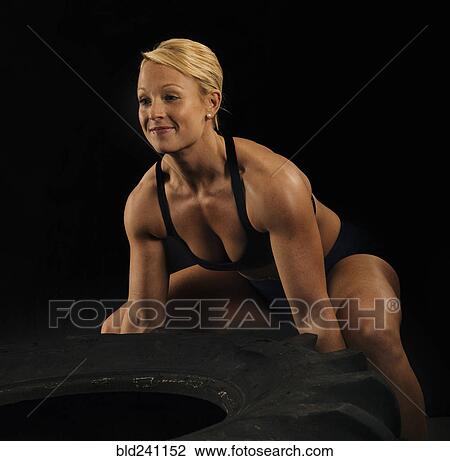 Caucasian woman lifting heavy tire View Large Photo Image Stock Image - Caucasian woman lifting heavy tire. Fotosearch