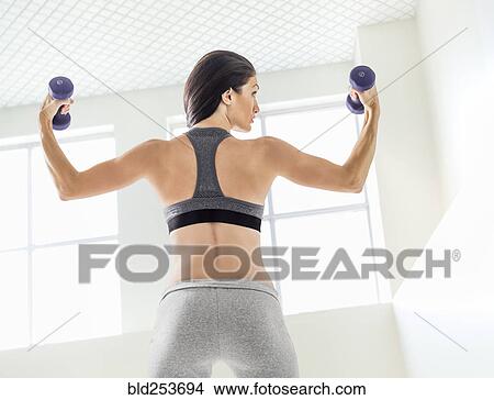 Picture - Caucasian woman lifting weights. Fotosearch
