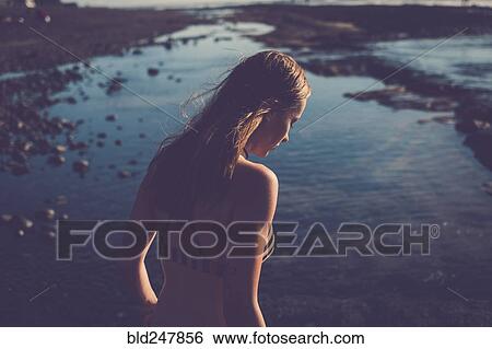 Caucasian woman looking down on beach View Large Photo Image Stock Photograph - Caucasian woman looking down on beach. Fotosearch