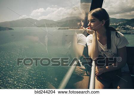 Caucasian woman looking out window on boat View Large Photo Image Picture - Caucasian woman looking out window on boat. Fotosearch