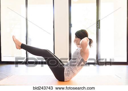 Stock Image - Caucasian woman performing sit-up. Fotosearch